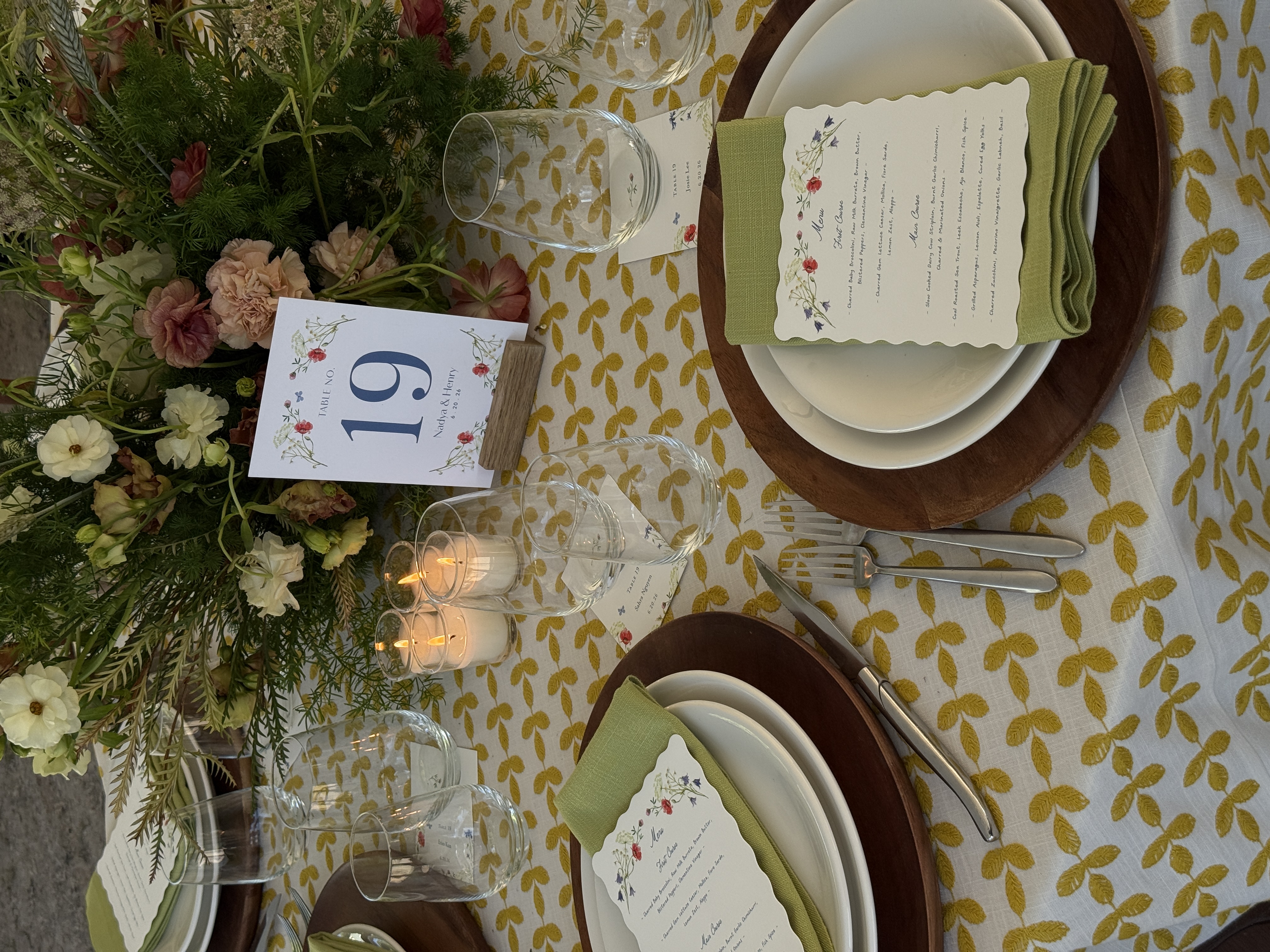 Wedding reception table with floral centerpiece, candles, and elegant place settings